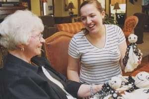 Junior Cayla Lawless makes a new friend while creating Halloween decorations at Kidron-Bethel Village retirement community.