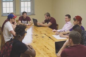 Justin Haflich, left in baseball cap, talks about his cold-calling experience in Professor Bobby Lloyd’s Sales class. Continuing clockwise around the table, other members of the class are Ben Carlson, Tyler Kaufman, Jaden Schmidt, Prof. Lloyd, Ryan Ford, Austin Mitchell, Chase Banister and Gary Jolivet.
