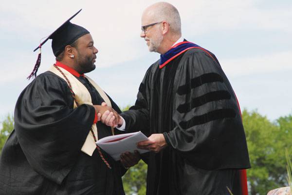 Los Angeles native Sheldon Nunnally, a social work graduate in the Class of 2015, receives congratulations from Brad Born, then vice president for academic affairs.