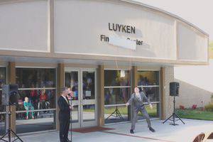 Jacob Miller pulls off the board to reveal the new name of the Luyken Fine Arts Center while President Perry White looks on.  Photo by Vada Snider.