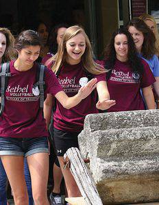Freshman volleyball players (from left) Caitlin Olson, Tia Goertzen and Mattison Hiebner touch the threshing stone on their way out of the first convoation of the 2013–14 school year.