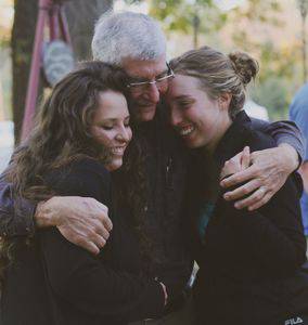 Jerry Weaver ’63, Hesston, hugs his granddaughters, Miranda ‘13, right, and Madelyn .  Photo by Vada Snider.