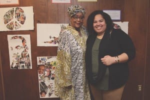 Michelle Armster, left, and Jean Butts ’09 of Bethel’s student life staff pose after the 2016 Martin Luther King Jr. Day celebration with artwork by Slate Creek Elementary School students.