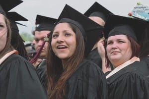 Assembled for Commencement 2016, Aida Martinez, left, and Amy Mason scan the crowd in Thresher Stadium to find the family and friends gathered to share in their big day.