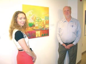 Rachel Epp Buller, left, and Mel Lehman with the painting “Untitled,” by Nidaa Kareem Risan, an Iraqi artist now living in Canada, that was part of the Building Bridges exhibit at Bethel and which the college purchased